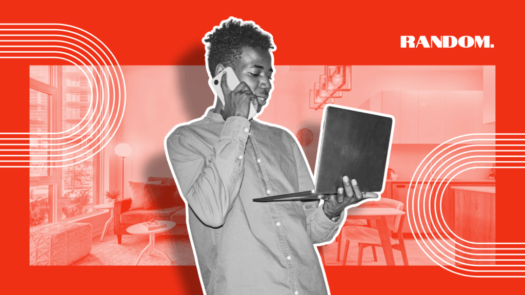 Young man on phone holding a laptop computer.